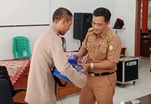 Camat Haurgeulis Rory Firmansyah memberikan hadiah sepeda kepada Maryono saat acara pelepasan purna tugas staf Pol PP